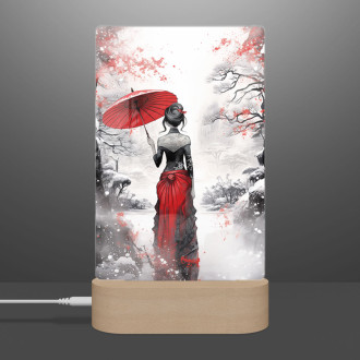 Lampa zasněžená krajina s ženou držící deštník